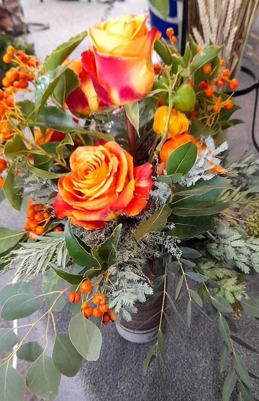 Ein schner gebundener Blumenstrau in herbstlichen Farben mit orangefarbenen Rosen.