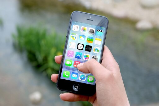 Eine Hand, die eine Handy h�lt. Auf dem Handy sieht man verschiedene Apps.